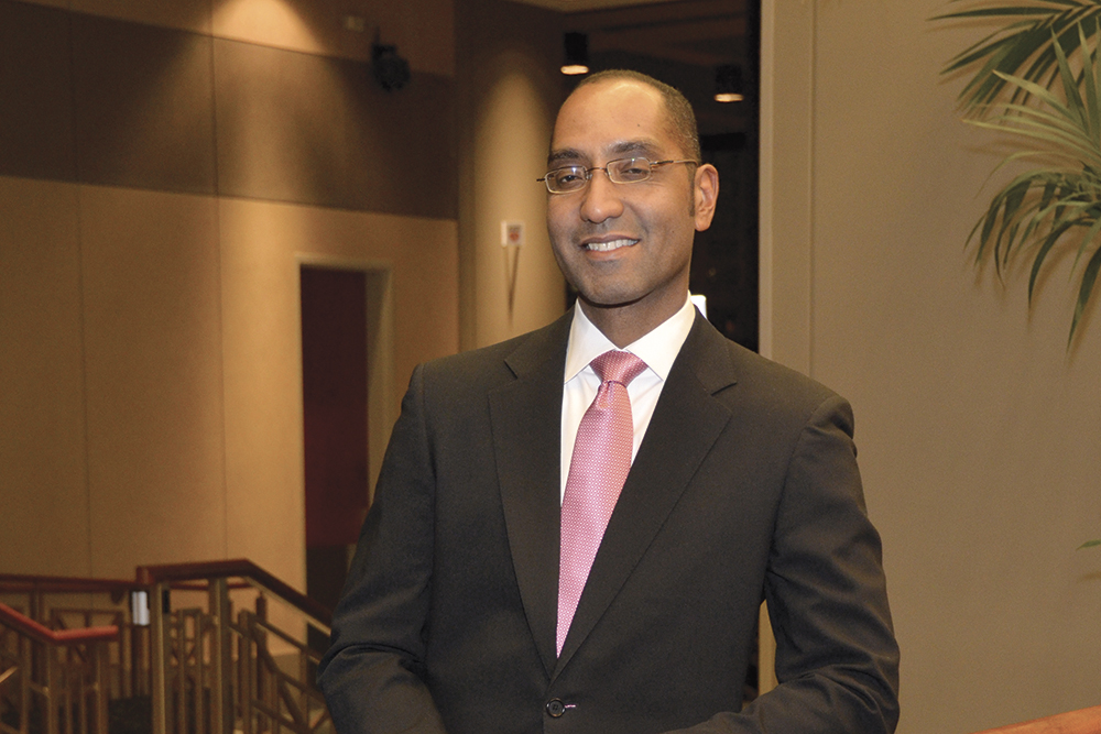 Diagnostic radiology residency alumnus Sean Pierce, MD, smiles while wearing a black suit and pink tie at an event.