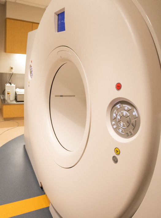 Close up of a white imaging scanner in an exam room.