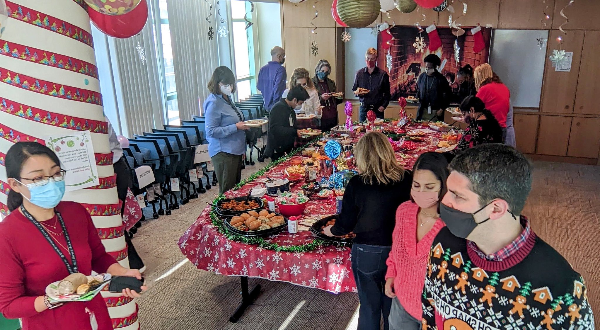 Party attendees mingle and enjoy the food and atmosphere of the holiday celebration.