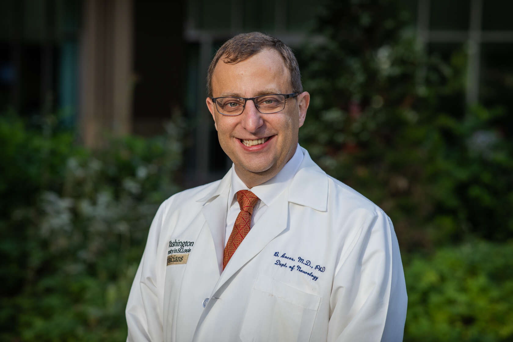 Headshot of Beau Ances, MD, PhD, as he stands outside in a white lab coat.