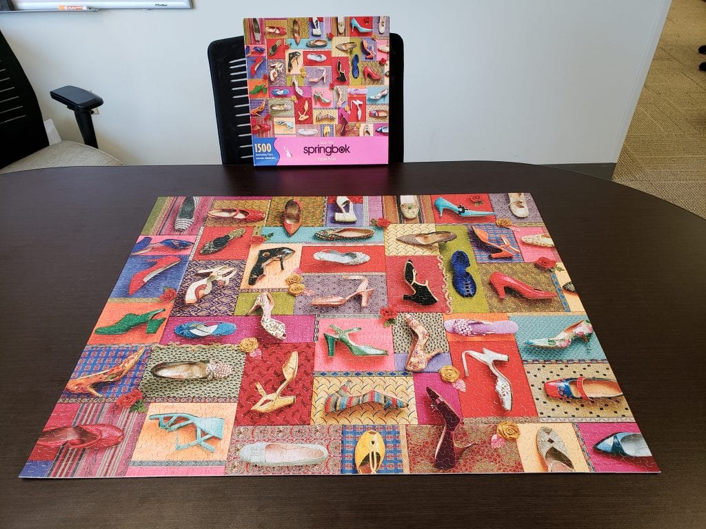 A square puzzle features a variety of different color heeled shoes. Each shoe is on a different color or pattern square background