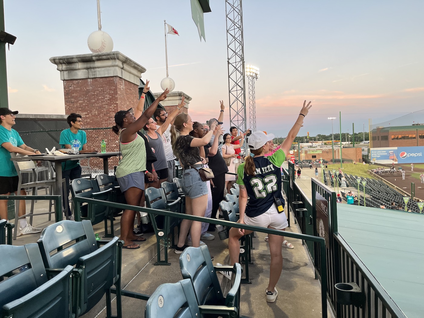 A Gateway Grizzlies employee leads members of the Benzinger Lab in singing "Take Me Out to the Ball Game."