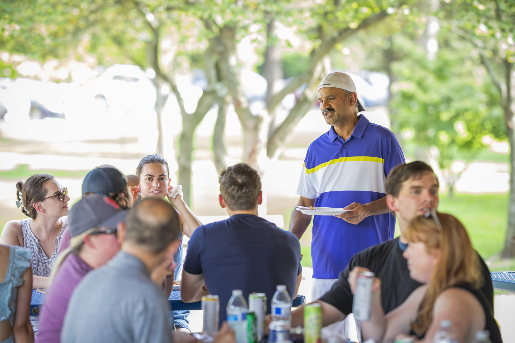 Associate Professor Naganathan Mani speaks with fellow attendees at the annual Residency Welcome BBQ at Faust Park.