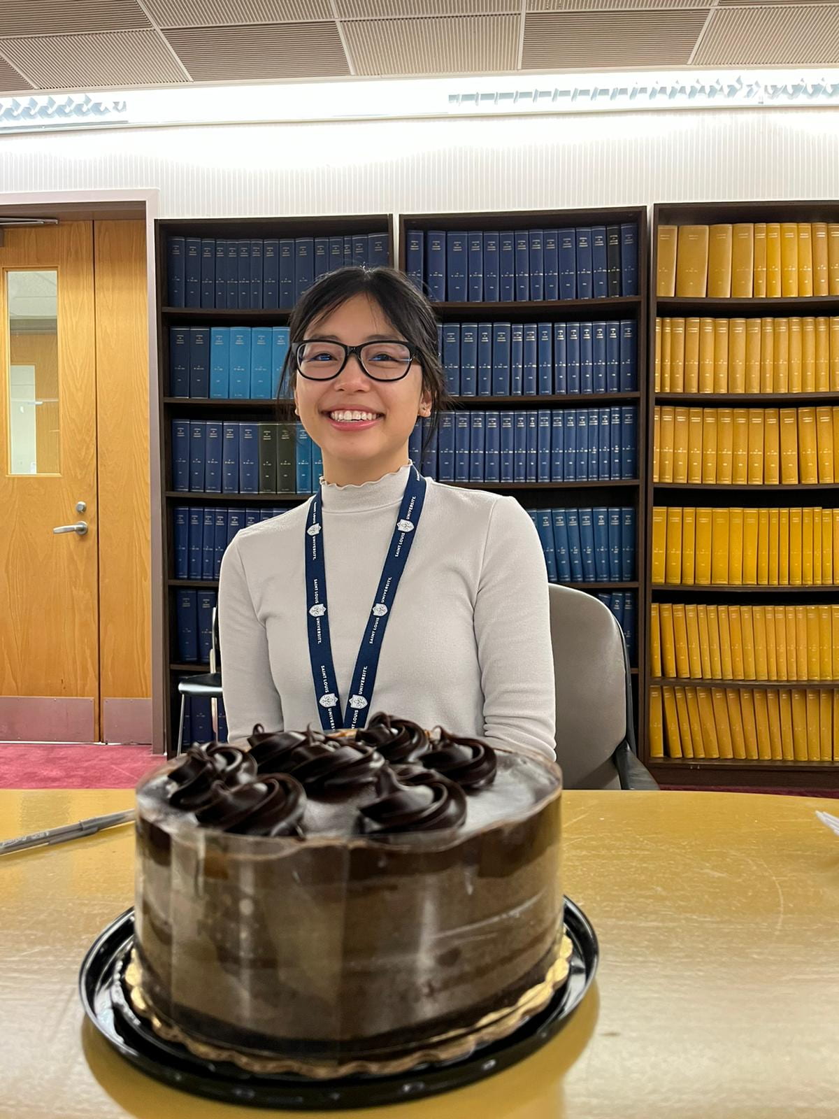 Emily Luc in front of a birthday cake