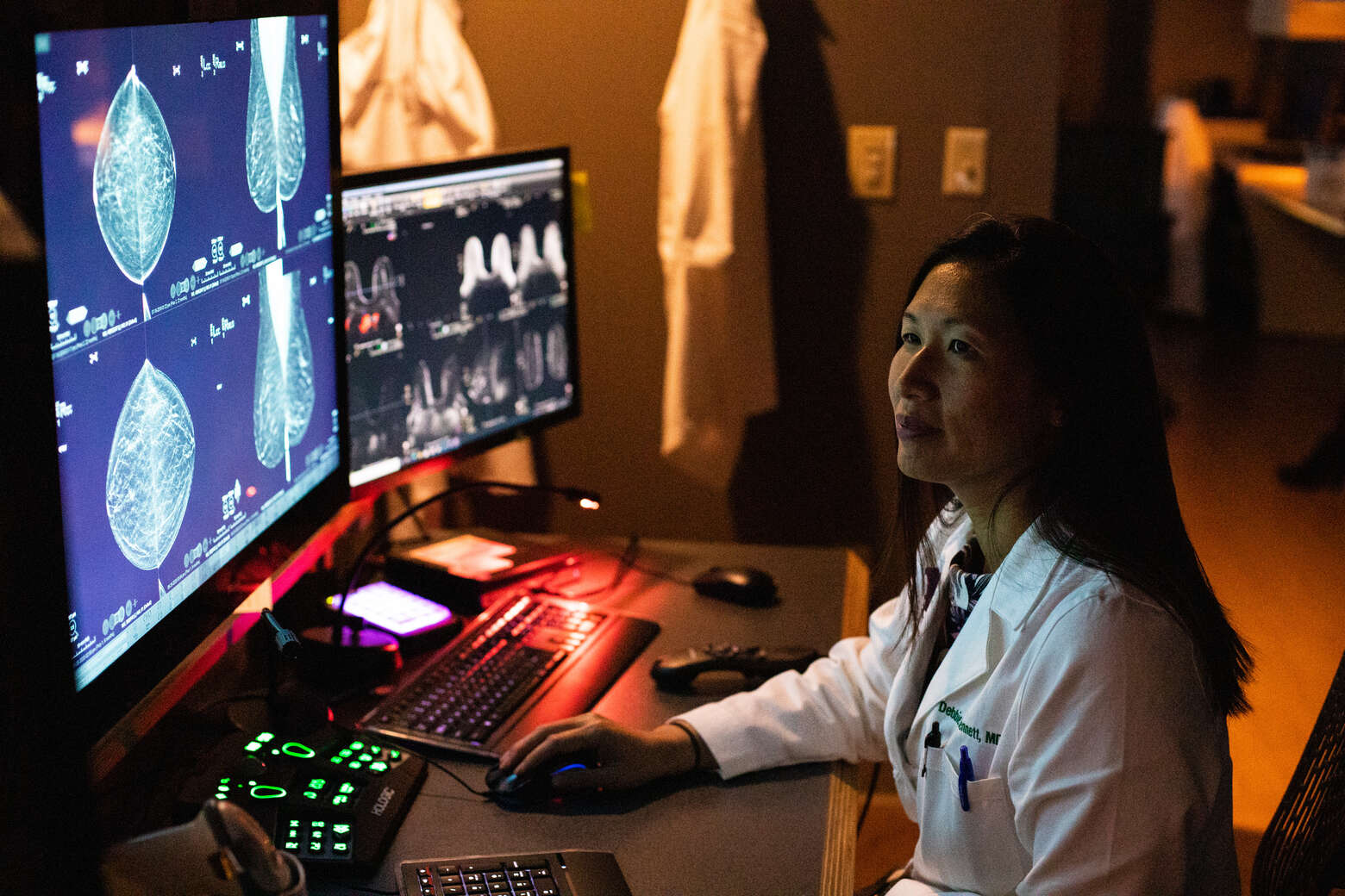 Debbie Bennett, MD, sits at a computer reading breast imaging scans in a reading room.