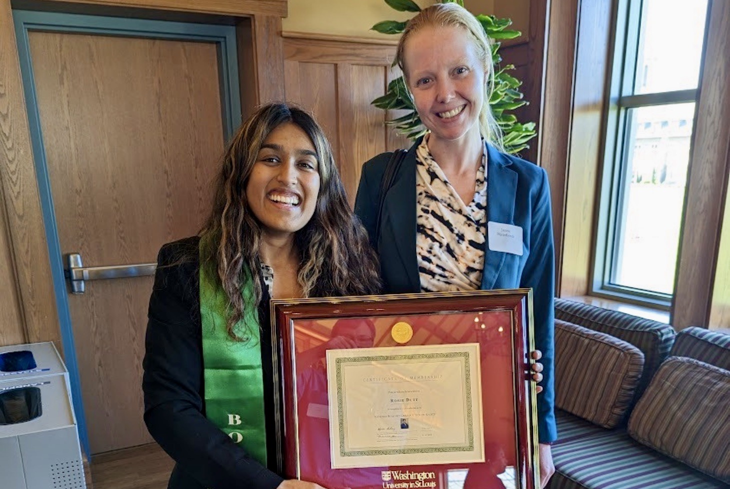 Graduate student Rosie Dutt stands next to Janine Bijsterbosch, PhD, while holding her Bouchet Graduate Honor Society certificate.