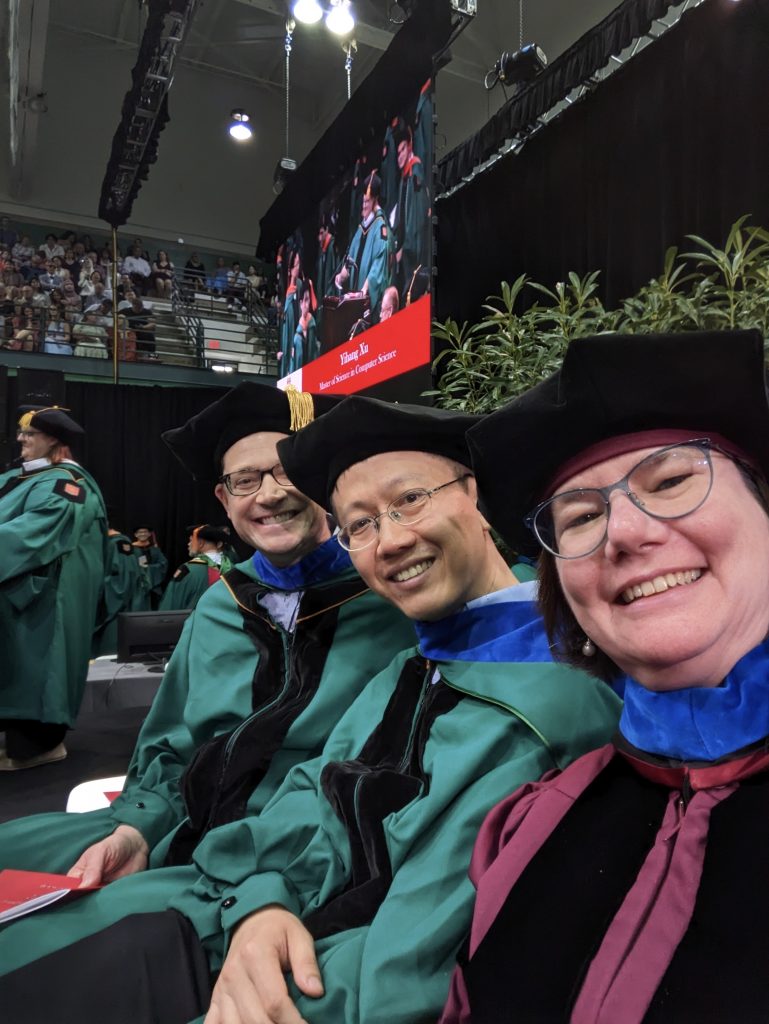 Tammie Benzinger, MD, PhD, and colleagues, dressed in graduation gowns, take a selfie during commencement.