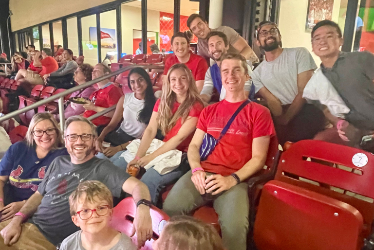 Faculty, trainees and their families watch the St. Louis Cardinals baseball team take on the Milawaukee Brewers at Busch Stadium.