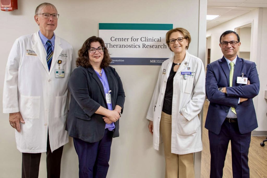 Richard Wahl, MD, Pamela Woodard, MD, Farrokh Dehdashti, MD, and Vikas Prasad, MD, PhD, pose in front of a sign for the Center for Clinical Theranostics Research.