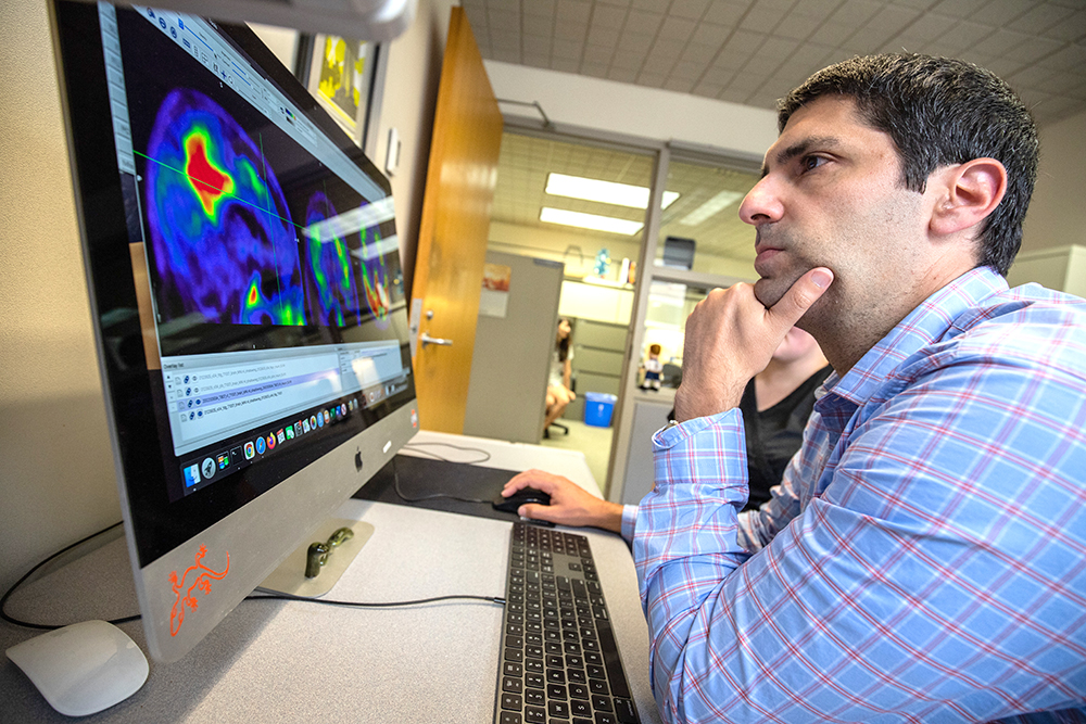 Dr. Brian Gordon, assistant professor of radiology and a principal investigator in MIR’s Neuroimaging Labs Research Center poses in front of a computer.