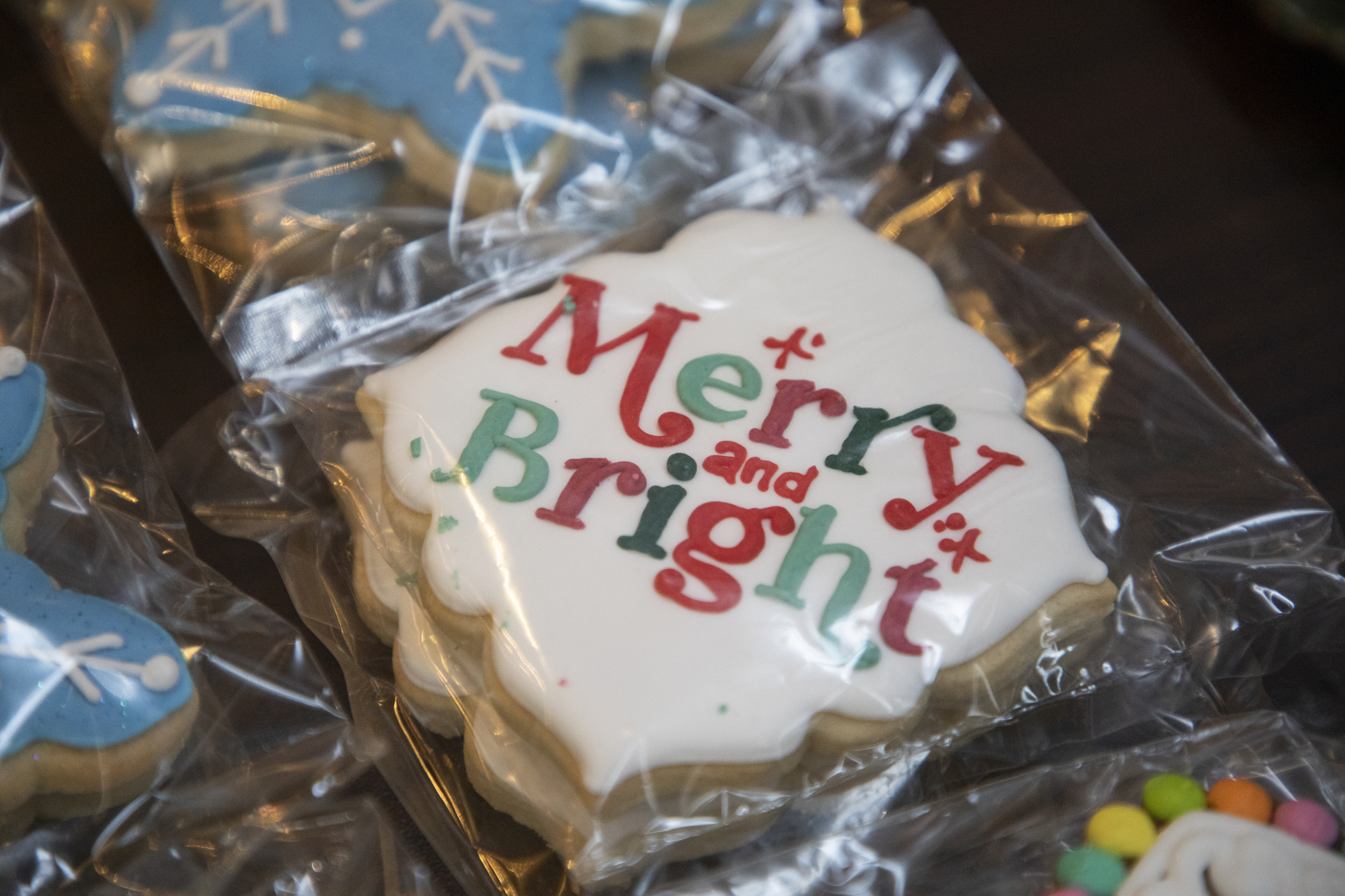 A close-up of a cookie that reads "Merry and Bright"
