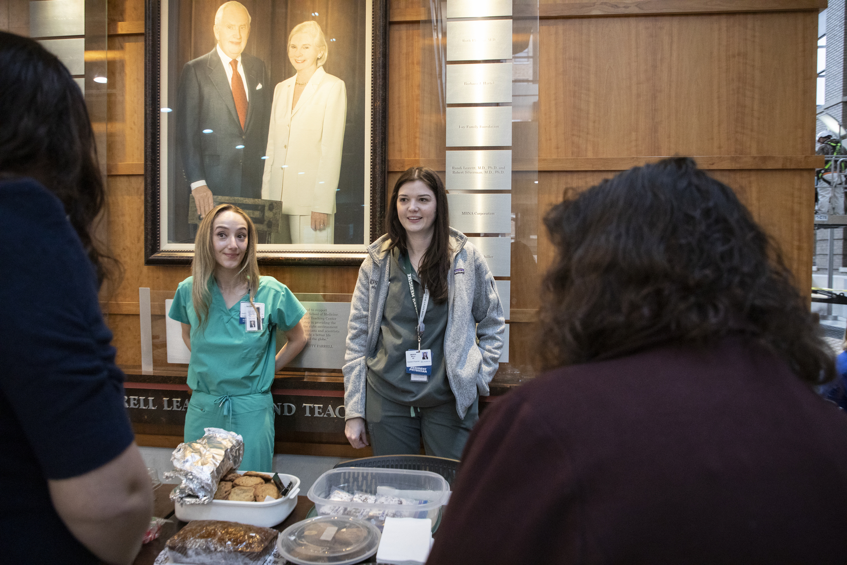 Residents stand behind their bake sale table full of treats.