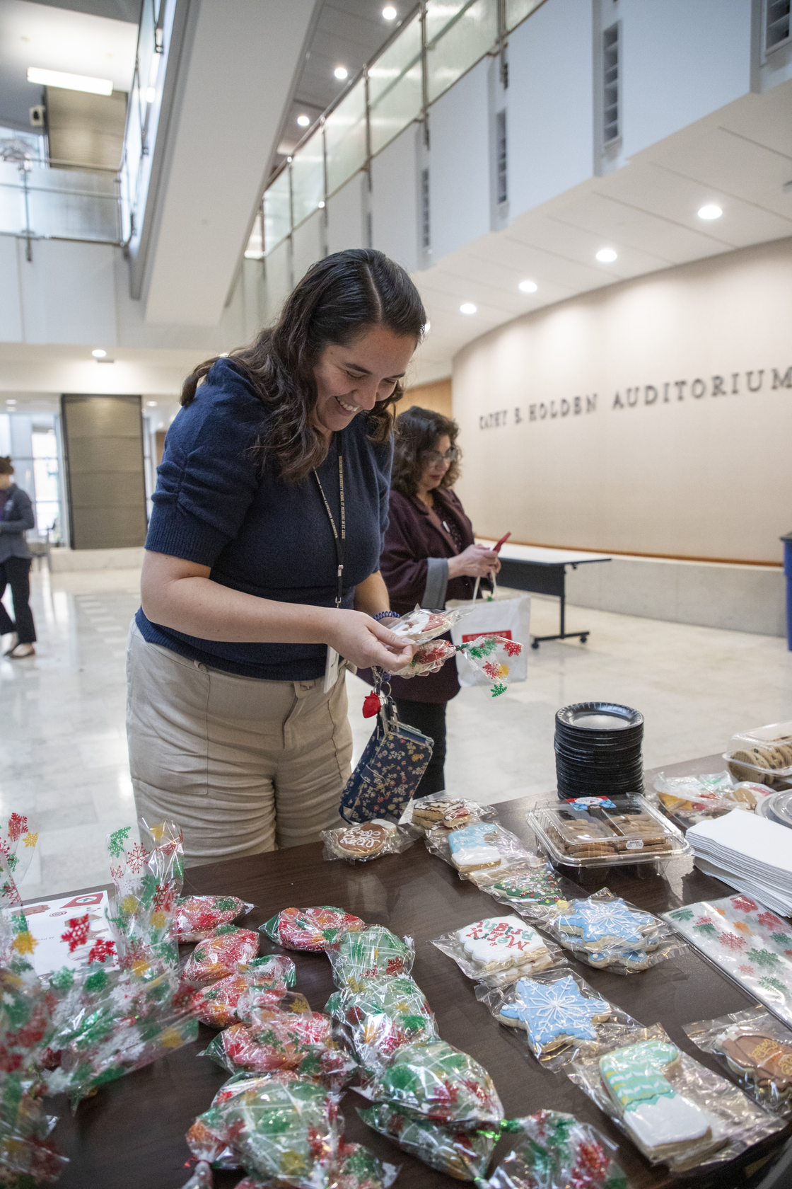 A WashU employee smiles and grabs a cookie from the resident bake sale table.